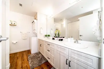 a white bathroom with a sink and a mirror at Exotic,LUSH,Rainforest,CR,Suite,King,U/G,Wifi in Edmonton