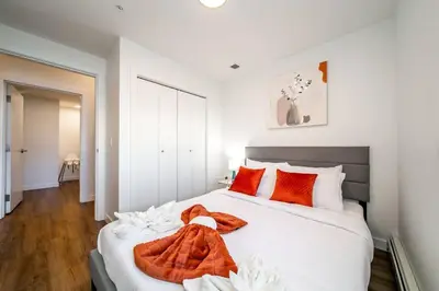 a bedroom with a large white bed with orange pillows at Exotic,LUSH,Rainforest,CR,Suite,King,U/G,Wifi in Edmonton