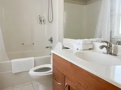 a white bathroom with a sink and a toilet at Serene and Secure Home Sweet Home with Office, 15 mins to Airport, 20 mins to Downtown, 90 mins to Banff in Calgary