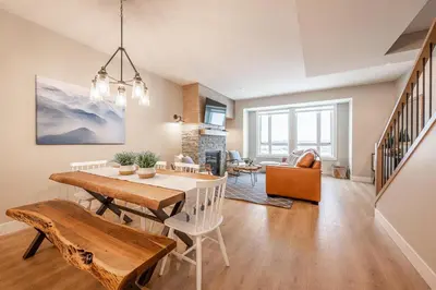 a dining room and living room with a table and chairs at Grizzly Ridge Getaway - Private Hot Tub, Mtn View & Sleeps 11 in Big White