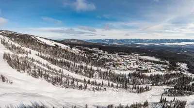 a snow covered mountain with trees and a town on it at Grizzly Ridge Getaway - Private Hot Tub, Mtn View & Sleeps 11 in Big White
