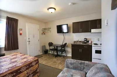 a kitchen with a couch and a table in a room at Blue Bell Inn in Fort Nelson