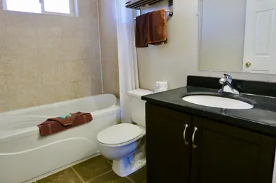 a bathroom with a sink and a toilet and a bath tub at Blue Bell Inn in Fort Nelson