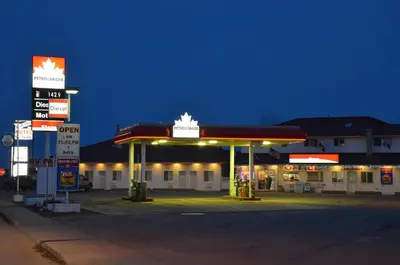 a gas station at night with a gas pump at Blue Bell Inn in Fort Nelson