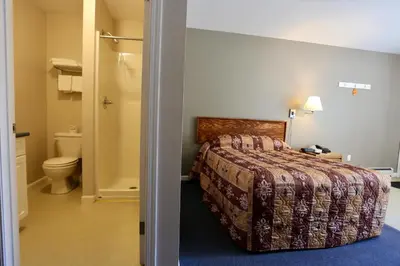 a hotel room with a bed and a toilet at Blue Bell Inn in Fort Nelson