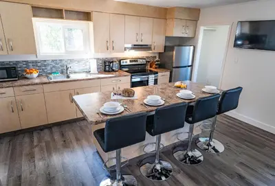 a kitchen with a large island with chairs in it at Downie Cottage by Revelstoke Vacations in Revelstoke