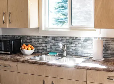 a kitchen sink with a bowl of oranges and a window at Downie Cottage by Revelstoke Vacations in Revelstoke