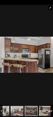 a kitchen with wooden cabinets and stainless steel appliances at Canmore Mountain Retreat. Hot Tub, Pool, King Bed! in Canmore
