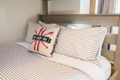 a bed with two pillows with a not allowed sign on it at 2BR in Greyhawk, Hot Tub and Sauna, Gas Fireplace, Secure Parking in Whistler