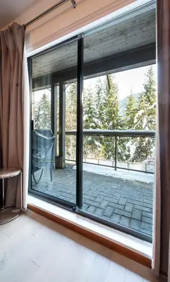 a window with a view of a patio at 2BR in Greyhawk, Hot Tub and Sauna, Gas Fireplace, Secure Parking in Whistler
