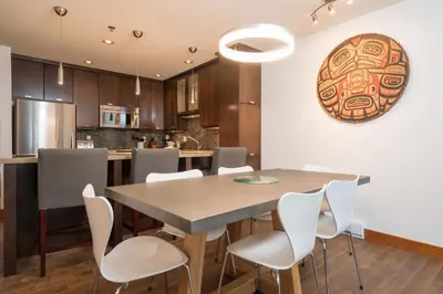 a kitchen and dining room with a table and chairs at 2BR in Greyhawk, Hot Tub and Sauna, Gas Fireplace, Secure Parking in Whistler