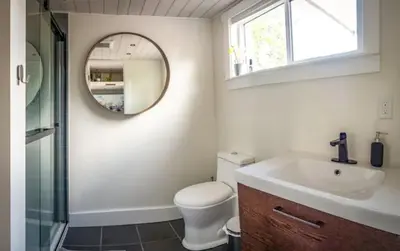 a bathroom with a toilet and a sink and a mirror at Golden Tiny Homes in Golden