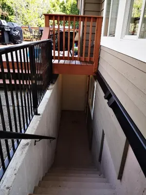 a staircase leading up to a porch with a wooden railing at Jimmy B&B in Surrey