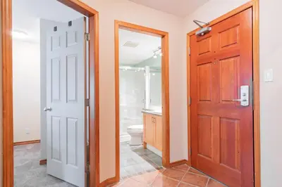 a bathroom with a toilet and a wooden door at The best ski in ski out two bedroom condo at Aspens in Whistler