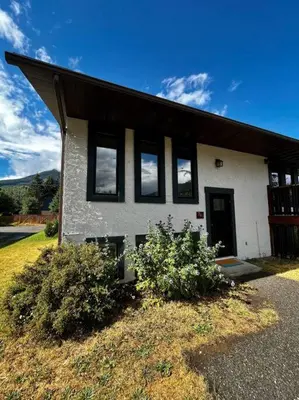 a house with black windows on the side of it at Two Bedroom House by Snow Valley Lodging in Fernie