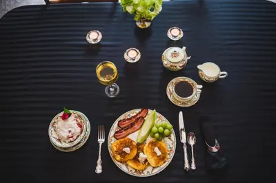 a black table with plates of food and glasses of wine at Misty Meadows B and B in Langford
