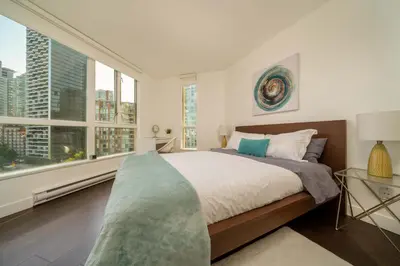 a bedroom with a large bed and large windows at Sunset Beach Walk 2BD+2BA+1PRK Yaletown in Vancouver
