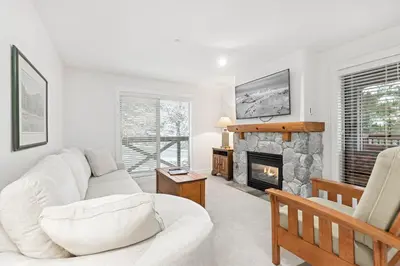 a living room with a white couch and a fireplace at Lost Lake Lodge by Whistler Premier in Whistler