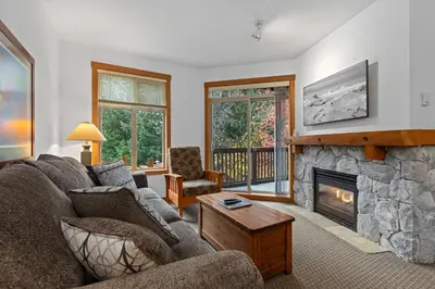 a living room with a couch and a fireplace at Lost Lake Lodge by Whistler Premier in Whistler