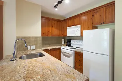 a kitchen with a white refrigerator and a sink at Lost Lake Lodge by Whistler Premier in Whistler