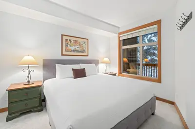 a bedroom with a large white bed and a window at Lost Lake Lodge by Whistler Premier in Whistler