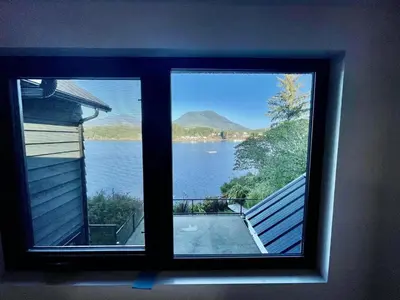 a window view of a lake from a house at Salt Loft - Oceanfront, Hot Tub And Firepit! in Ucluelet