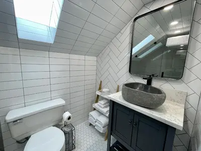 a bathroom with a sink and a mirror at Salt Loft - Oceanfront, Hot Tub And Firepit! in Ucluelet