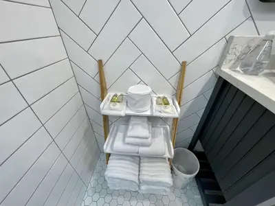 a bathroom with a sink with towels on a shelf at Salt Loft - Oceanfront, Hot Tub And Firepit! in Ucluelet
