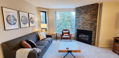 a living room with a couch and a fireplace at 1BR in Marquise, Dog Friendly, Close to Ski Hill, Pool, Sauna, Hot Tub, Fitness Suite, AC in Whistler