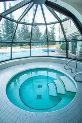 a large swimming pool in a building with a window at 1BR in Marquise, Dog Friendly, Close to Ski Hill, Pool, Sauna, Hot Tub, Fitness Suite, AC in Whistler