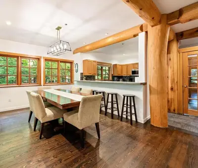 a dining room with a table and chairs and a kitchen at Ski In/Ski Out Luxury Home w/ jacuz/ fireplace in Whistler