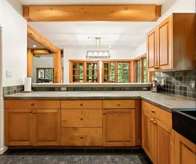 a kitchen with wooden cabinets and a large island at Ski In/Ski Out Luxury Home w/ jacuz/ fireplace in Whistler