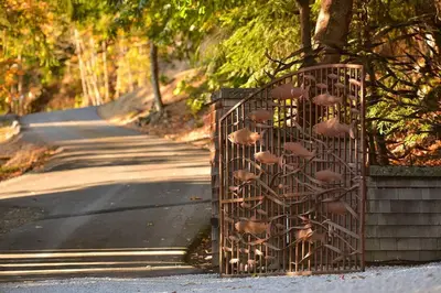 a wrought iron fence with mushrooms on it next to a road at Salishan Tree House Suite by EMR Vacation Rentals in Cowichan Bay