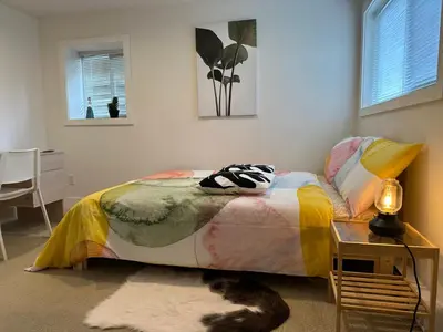 a bedroom with a bed and a cat laying on the floor at Private room in a Shared house in Vancouver