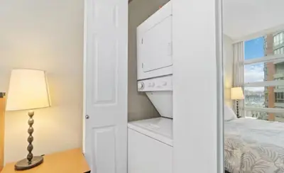 a white bedroom with a bed and a window at 1BD+Den condo, with free parking in Downtown! in Vancouver