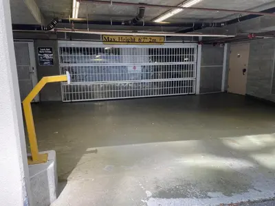 an empty parking garage with a metal cage at 1BD+Den condo, with free parking in Downtown! in Vancouver