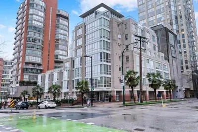 an empty street in a city with tall buildings at 1BD+Den condo, with free parking in Downtown! in Vancouver