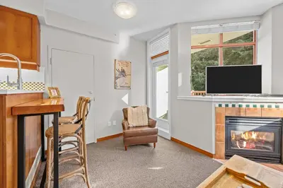 a living room with a fireplace and a tv at Alpenglow Lodge Cozy Studio with Den by MVA in Whistler