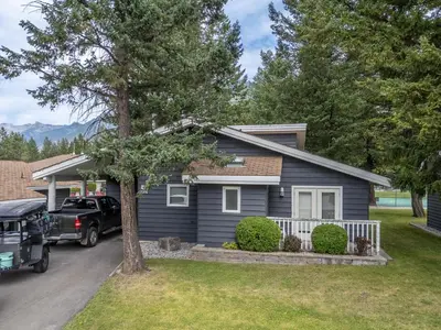 a blue house with a car parked in the driveway at RidgeView Resort in Radium Hot Springs
