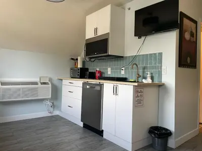 a kitchen with white cabinets and a black refrigerator at Amazing mountain views 1bd Apartment Canmore Banff in Canmore