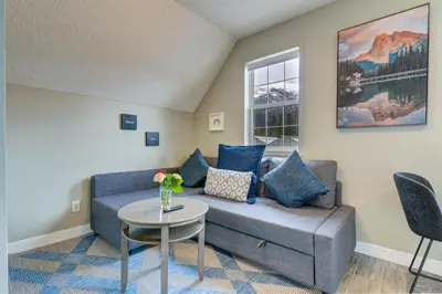 a living room with a couch and a table at Amazing mountain views 1bd Apartment Canmore Banff in Canmore