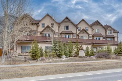 a large house on the side of a road at Amazing mountain views 1bd Apartment Canmore Banff in Canmore