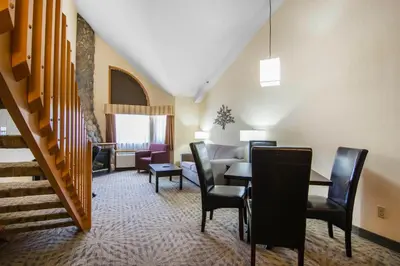 a living room with a table and chairs and a couch at Chateau Canmore in Canmore