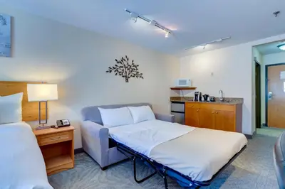 a hotel room with a bed and a couch at Chateau Canmore in Canmore