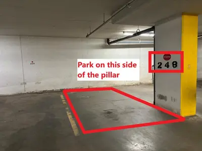 a parking lot with a sign on the side of the pillar at Stylish 1BR, Stampede & Free Parking by Doorbed in Calgary