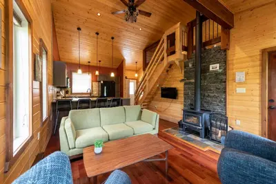 a living room with a couch and a fireplace at The Qu INN - Cozy Cabin in Parson