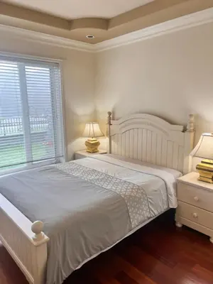 a white bedroom with a large bed and a window at Lucky suite, two-bedroom suite with independent entrance in Richmond close to YVR in Richmond