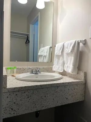 a bathroom counter with a sink and a mirror at Anavada Inn & Suites - Grande Prairie in Grande Prairie