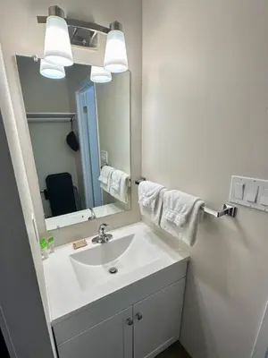 a bathroom with a white sink and a mirror at Anavada Inn & Suites - Grande Prairie in Grande Prairie