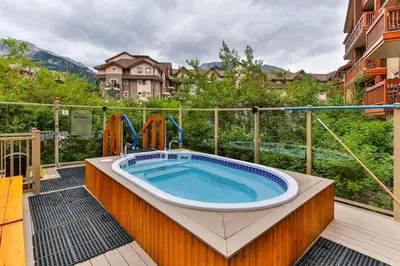 a jacuzzi tub on a balcony of a building at Luxury Falcon Crest Lodge 1 Bedroom 1 Pullout Kitchen Hot Tub in Canmore